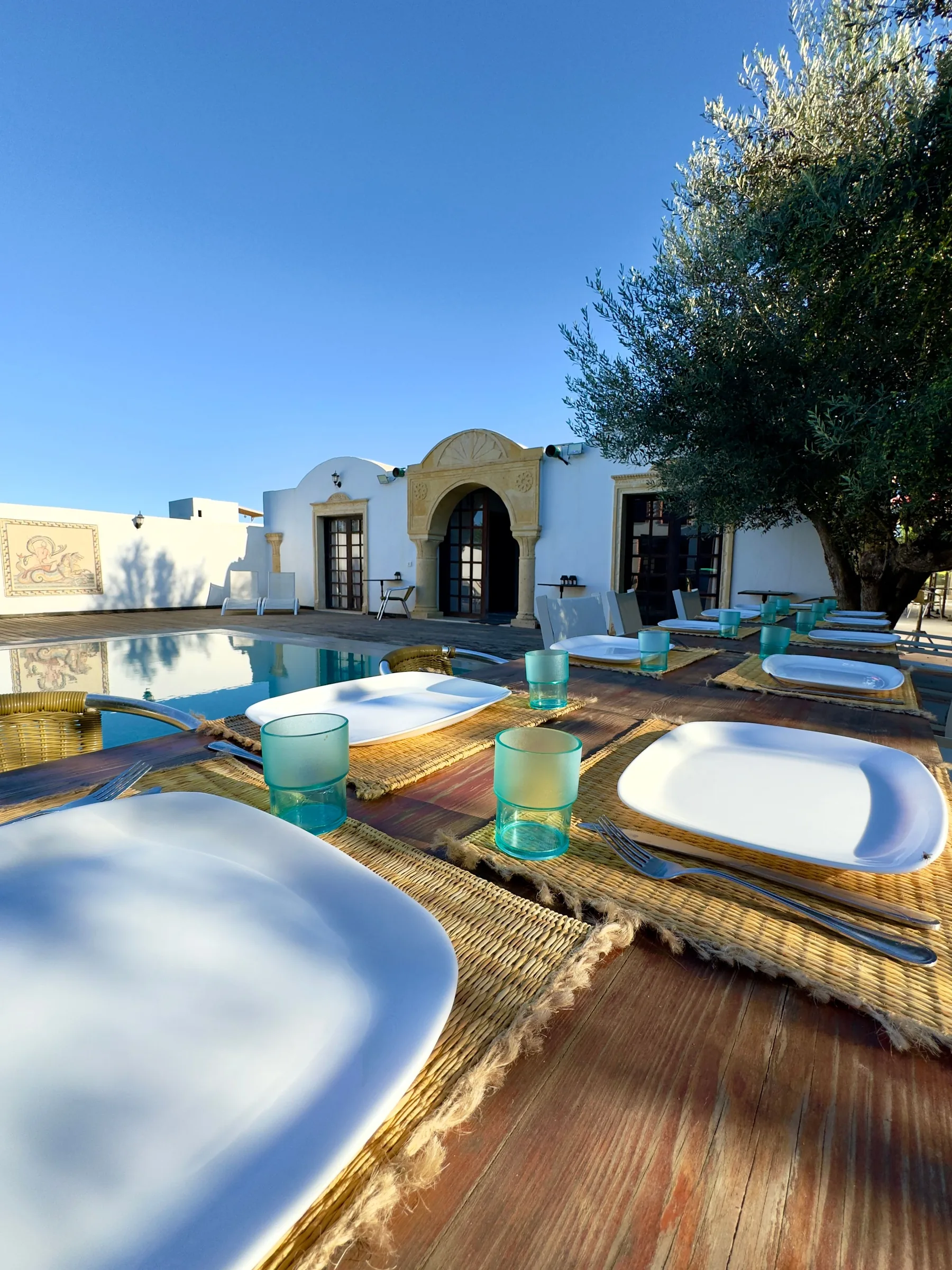 Table set for a shared meal beside the pool at the retreat property